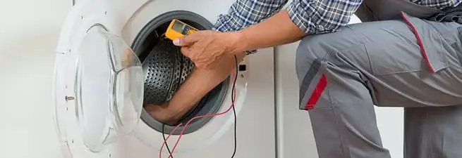 Dryer repair technician inspecting and repairing a clothes dryer in Cambridge, MA