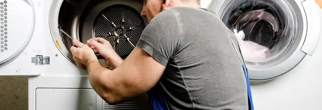 Dryer repair technician fixing a clothes dryer drum in Cambridge, MA