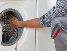 Dryer repair technician diagnosing and servicing a clothes dryer in Cambridge, MA