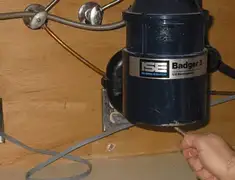 Garbage disposal repair technician tightening the mounting ring under a sink in Cambridge, MA