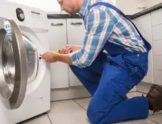 Washing machine repair technician servicing a front-load washer in Cambridge, MA