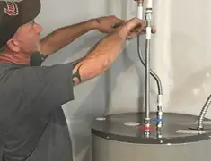 Water heater repair technician tightening supply line connections in Cambridge, MA